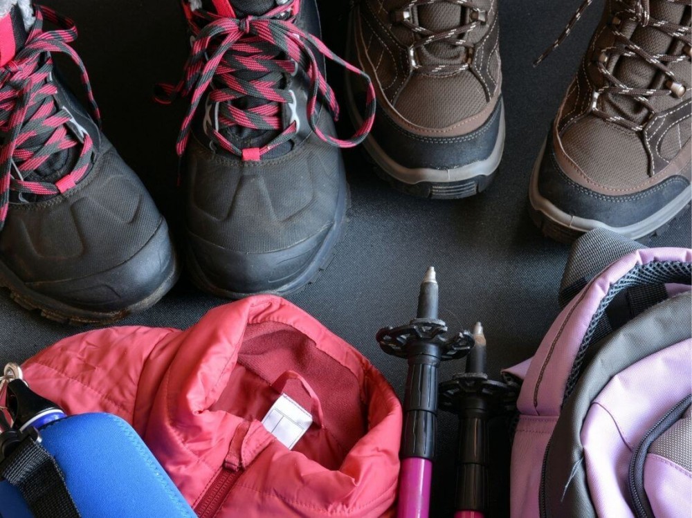 Turistické topánky, bunda, paličky a ruksak pripravené na turistiku. 