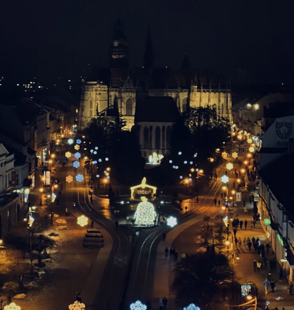 Pohľad zhora na vianočne vysvietené mesto s vianočnými trhmi.