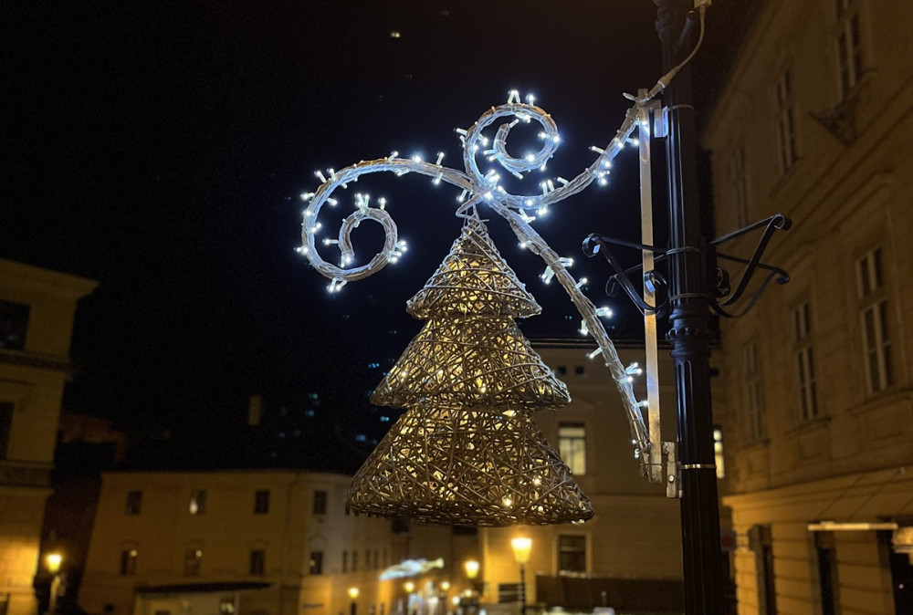 Dekorácia svietiaceho vianočného stromčeka na lampe v meste.